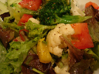 Close up of mixed greens with vegetables and dressing