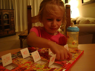 Little girl sitting and opening doors on advent calendar 