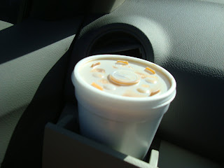 Coffee in to-go cup in cup holder in car