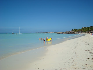 White sandy beach with people in water