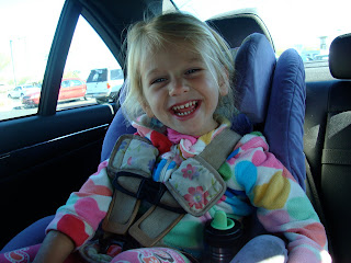 Young girl sitting in carseat smiling