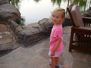 Young girl standing in front of rocks in front of water