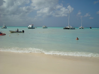 Beach in Aruba showing waves and boats in water