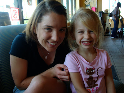 Woman in black shirt next to young girl smiling
