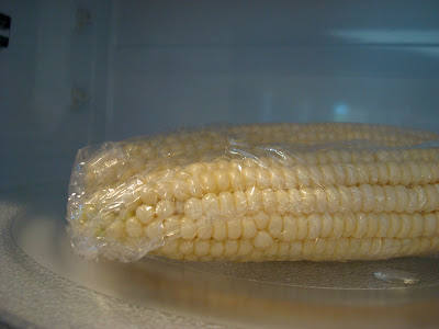 Close up of corn in microwave in plastic wrap