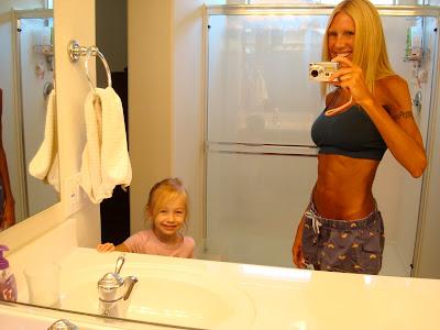 Woman and child in bathroom taking photos in mirror