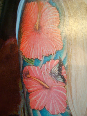Photo in magazine of arm tattoo of flowers and butterfly