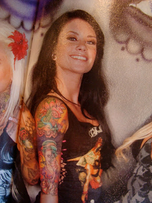 Dark haired woman in magazine with full sleeve tattoo