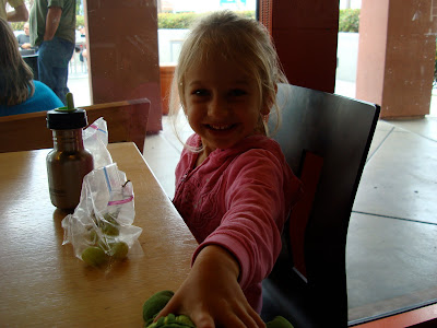 Young girl eating snacks at table and smiling