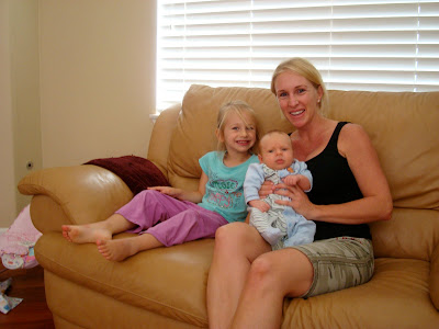 Woman and child sitting on couch holding baby