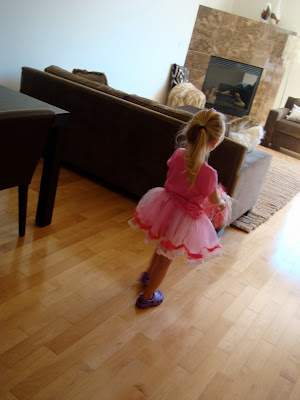 Young girl wearing tutu in dining room