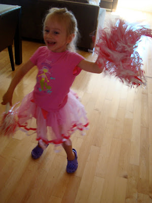 Young girl wearing pink tutu dancing in kitchen