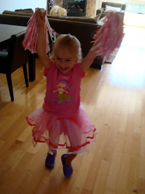 Young girl in tutu holding pompoms