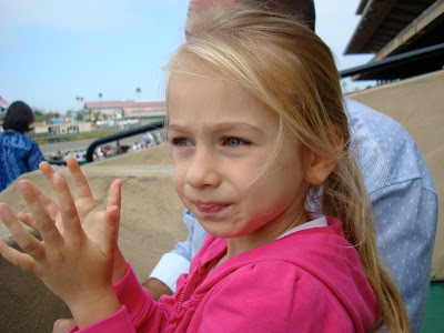 Young girl clapping while watching horse race