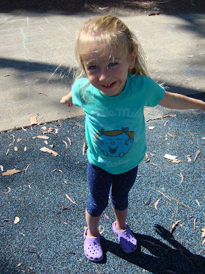 Young girl standing and smiling swinging arms at park