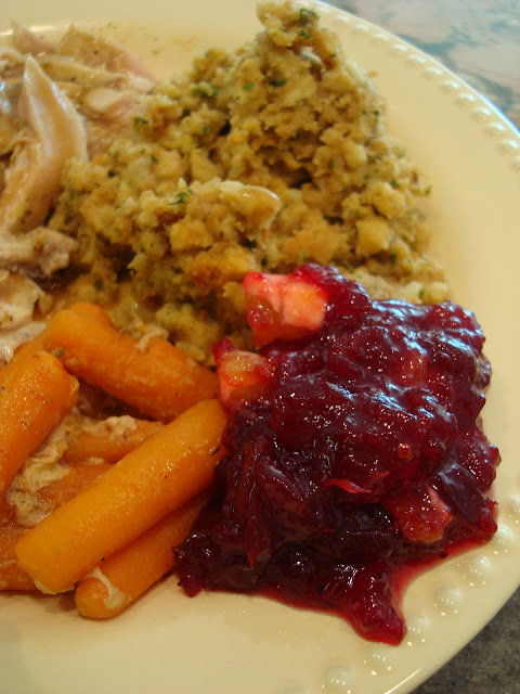 Close up of cranberry sauce, carrots and stuffing on plate