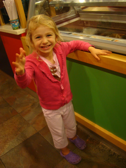 Young girl standing smiling at ice cream counter