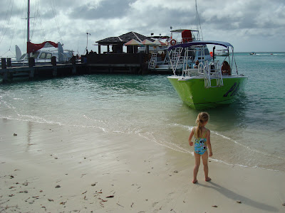 Young girl in bathing suit walking towards water with boat