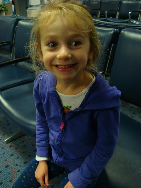 Up close of young girl making silly face on chair at airport