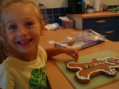 Young girl smiling while decorating gingerbread man