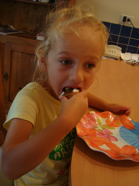 Young girl eating portion of gingerbread man at table
