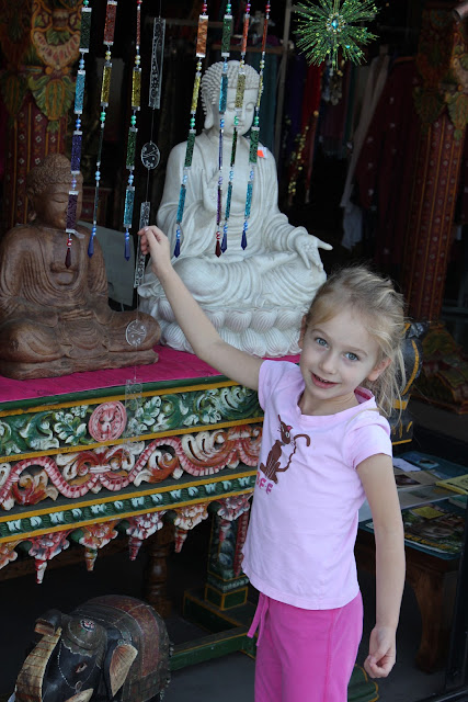 Young girl standing by statues on a table