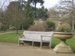 Bench in garden with stone urn