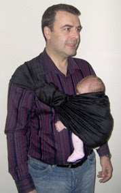 Ο μπαμπάς της Ρέας, φοράει την νεογέννητη κόρη του σε ring sling έχοντας τυλίξει την ουρά γύρω απ' τους κρίκους του μάρσιπου