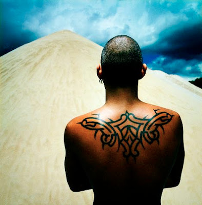 A Latino man with back tribal tattoo