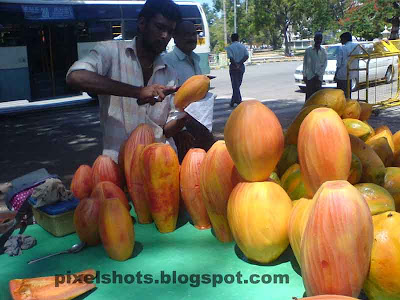 papaya fruits photographed from street side papaya seller in kerala,kappakka, kappayka, pappaya friut medicinal uses, slice ripe pappaya fruits, street fruit merchants, skin peeled ripe red pappaya fruits, photograph of fruits from fruit sellers in kerala,fruits photography