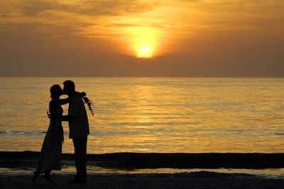 couple kissing in front of sunset