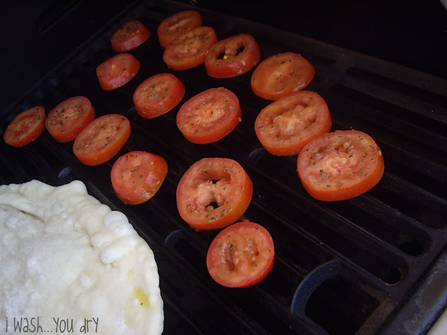 Seasoned tomatoes slices on a grill. 