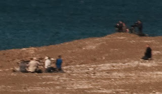Fotógrafos de naturaleza, apostados en las 2 casamatas del Canal de Ataque en Punta Norte, vistos desde el mirador a 800m de distancia
