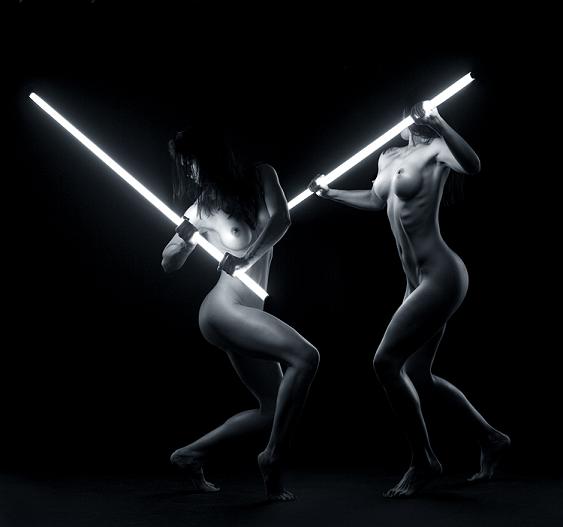 mulheres nuas brigando com sabres de luz