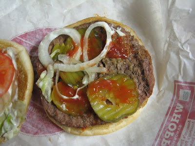 Close up of Burger King Whopper patty with pickles and onions