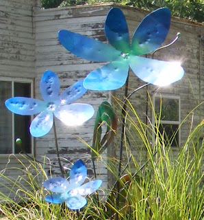Blue metal art flowers glistening in the sun