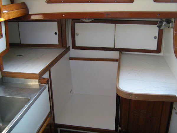 Install Corian counters and teak fiddles