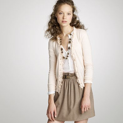 A cream cardigan with a mini skirt.