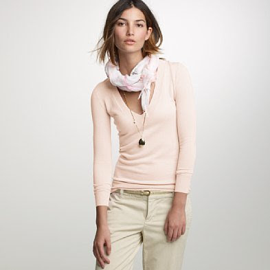 A pink long sleeved shirt with khaki pants.