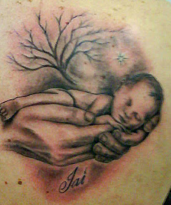 Small baby sleeping in hands tattoo.