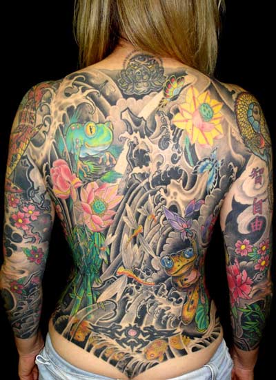 Back piece tattoo with frogs and flowers.