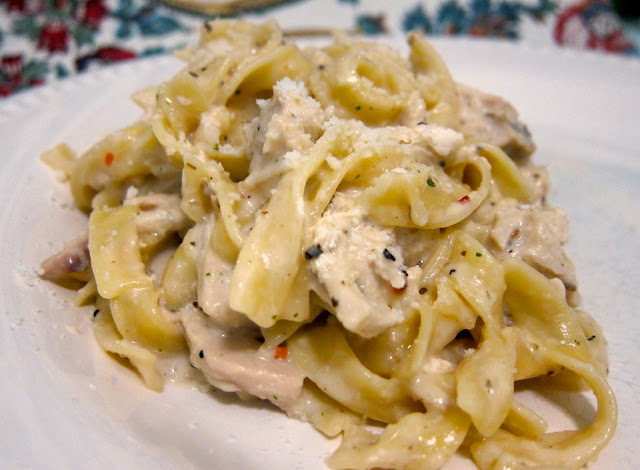 A mountain of creamy chicken noodles sits on a white plate