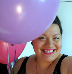 a headshot picture of a plus size woman with a purple and pink baloon behind her head