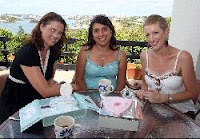 Tania Targett, Marina Sousa, & Pia Hopkins looking at the scrapbook Tania put together to remember her son Jacks brief life. 