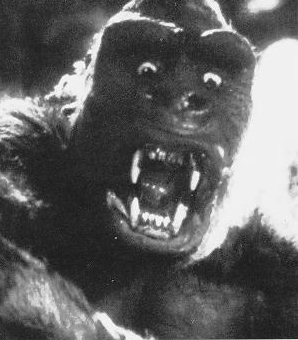 Imagem em preto e branco do rosto do King Kong, com olhos arregalados e boca aberta.