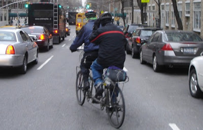 Couple bicycle commuting on a tandem in New York City