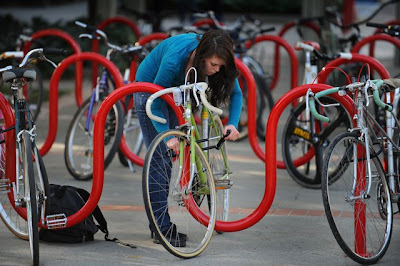 Shawna Sanders, a biology student at Sacramento City College, secures her bike to a rack with a U-shaped lock before heading to class