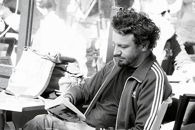 portrait d'un homme lisant un livre à la terrasse d'un café, photo dominique houcmant, goldo graphisme