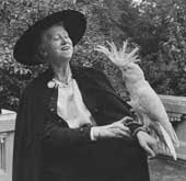 Marianne Moore in cape and hat with cockatoo