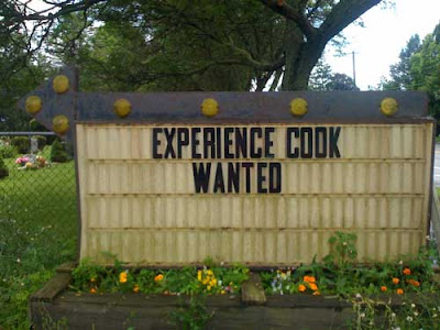 Black letters on a white plastic sign board EXPERIENCE COOK WANTED